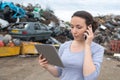 Female worker phoning with clipboard at metal scrap yard Royalty Free Stock Photo