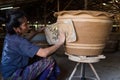 Female worker printing Dragon design with white clay