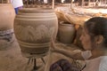 Female worker prints Dragon pattern on clayed jar