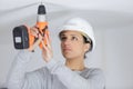 female worker screwing something in ceiling Royalty Free Stock Photo