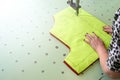 Female worker on a sewing manufacture uses electric cutting fabric machine. Royalty Free Stock Photo