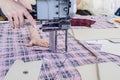 Female worker on a sewing manufacture uses electric cutting fabric machine. Textile industry, clothing production, fabric cutting Royalty Free Stock Photo