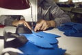 Female worker at shoe factory making sneaker details on industrial sewing machine Royalty Free Stock Photo