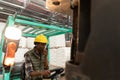 Female worker talking on walkie-talkie while driving forklift in warehouse Royalty Free Stock Photo