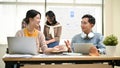 A female worker in a tech company is discussing and sharing her ideas with a male colleague