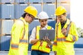 Female worker and two male workers wearing yellow safety vests using a laptop. Royalty Free Stock Photo