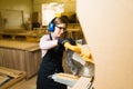 Female worker using a bench saw and wearing protective equipment Royalty Free Stock Photo