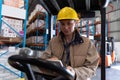 Female worker using digital tablet while sitting in forklift in warehouse Royalty Free Stock Photo