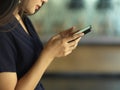 Female worker using smartphone in blurred office background Royalty Free Stock Photo