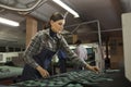 Female worker using special cutting machine in workshop of shoe manufacturing factory Royalty Free Stock Photo