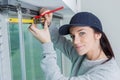 Female worker using tape measure window in construction site Royalty Free Stock Photo