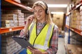 Female Worker Wearing Headset In Logistics Distribution Warehouse Using Digital Tablet Royalty Free Stock Photo