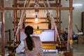 A female worker working on a Chinese Ancient weaving machine in the museum of jiangning weaving bureau, in Nanjing, China