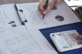 Female working in office, studying using calculator and writing something with documents and chart on table Royalty Free Stock Photo