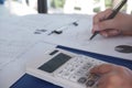 Female working in office, studying using calculator and writing something with documents and chart on table Royalty Free Stock Photo