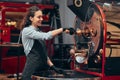 Female working with rosting coffee machine. Front view Royalty Free Stock Photo