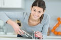 Female working on sink using wrench Royalty Free Stock Photo