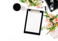 Female workspace with clipboard, office accessories, coffee and