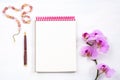 Mockup with notepad, pen and pink orchid, top view Royalty Free Stock Photo