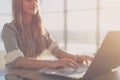 Female writer typing using laptop keyboard at her workplace in the morning. Woman writing blogs online, side view close Royalty Free Stock Photo