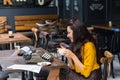 Female writer with vintage typewriter in a coffee shop