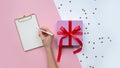 Female writing wish list near christmas gift. Copy space Royalty Free Stock Photo