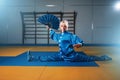 Female wushu master exercise with fan, martial art