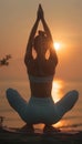 Female yoga practitioner gracefully holds tree pose at beach during stunning sunset