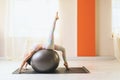 A female yoga practitioner performs a variation of Urdhva Dhanurasana with a ball, bridge pose Royalty Free Stock Photo