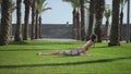 Yoga trainer doing cobra pose in park. Woman exercising yoga on green grass
