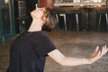 Female yogi in a backbend pose with open arms in her vinyasa flow yoga practice wearing a black t-shirt indoors