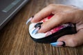 Females hand with manicured nails holds computers mouse Royalty Free Stock Photo