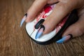 Females hand with manicured nails holds computers mouse Royalty Free Stock Photo