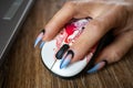 Females hand with manicured nails holds computers mouse Royalty Free Stock Photo