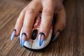Females hand with manicured nails holds computers mouse Royalty Free Stock Photo