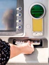 Females hand withdrawing cash from a cash machine