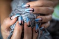 Females hands with manicured nails holding yarn ball with woolen thread