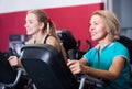 Females riding stationary bicycles in gym Royalty Free Stock Photo