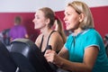Females riding stationary bicycles in gym Royalty Free Stock Photo