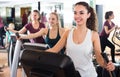 Females training on elliptical trainers in fitness club