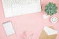 Femine office desktop with office accessories on pink background. Womens workspace with succulent, candle and cosmetics. Royalty Free Stock Photo