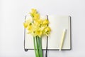 femine workspace. white work desk with notepad, pen and bouquet spring flower. Royalty Free Stock Photo