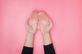 Feminime hands with soapy bubbly foam on pink background Royalty Free Stock Photo