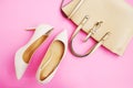 Feminine accessories flat lay. Woman shoes and bag on pink background. Beige color woman accessories. Text space. Top view.