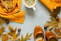 Feminine autumn accessories. Scarf and shoes, cup of coffee, oak leaves and acorns on gray wooden background Royalty Free Stock Photo