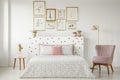 Feminine bedroom interior with a double bed with dotted sheets,