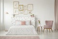 Feminine bedroom interior with white walls, polka dot bedding, p