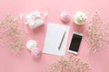 Feminine desk workspace in white and pink colors with small baby`s-breath flowers gypsophila. Royalty Free Stock Photo