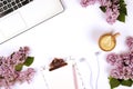 Top view of female worker desktop with laptop, flowers and different office supplies items. Feminine creative design workspace.