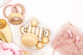 Feminine desktop with gold and pink earbuds, purse and sweet treats